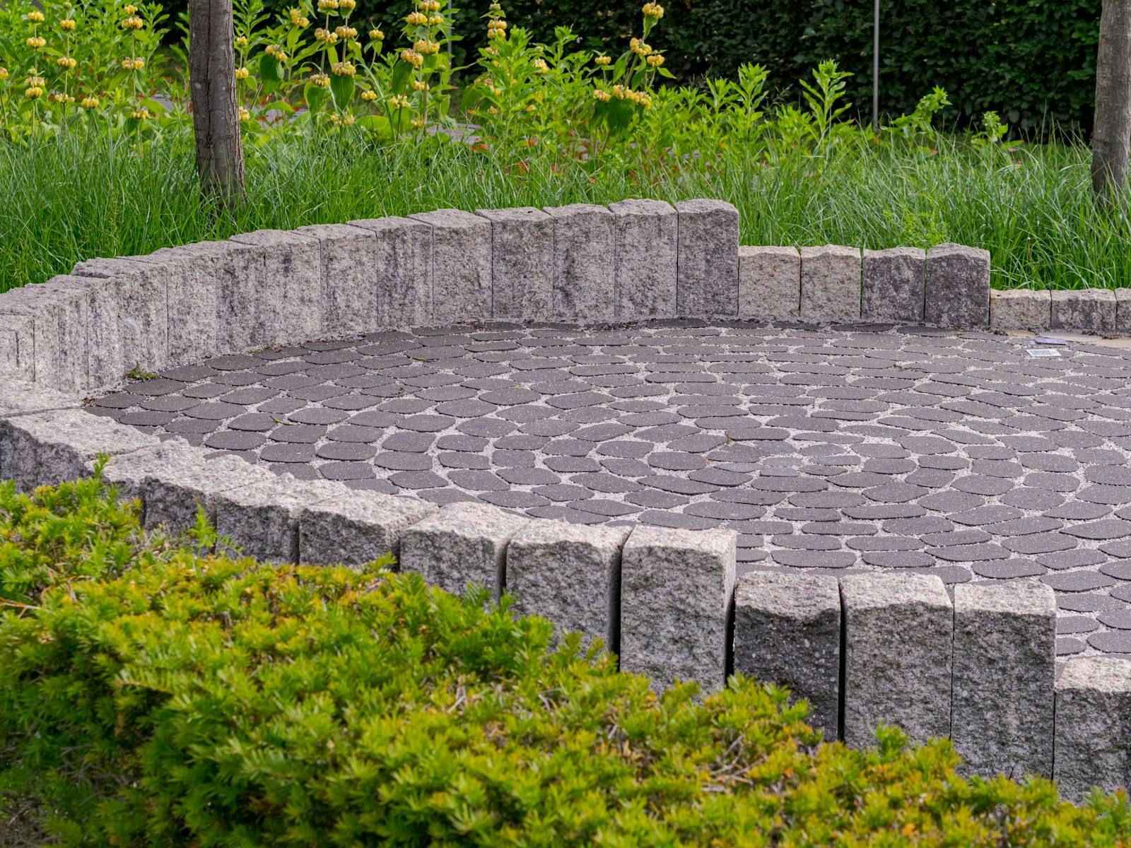 Circular paved patio with a low stone wall