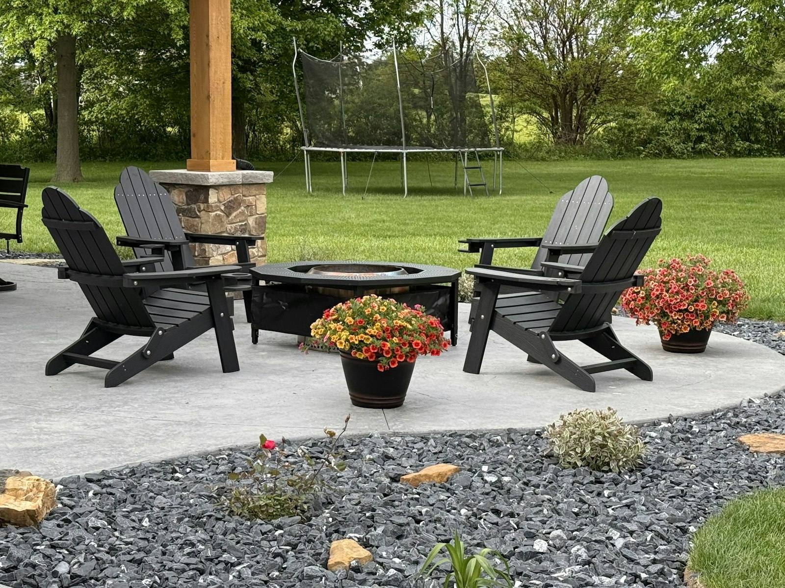 Backyard patio with Adirondack chairs around a fire pit
